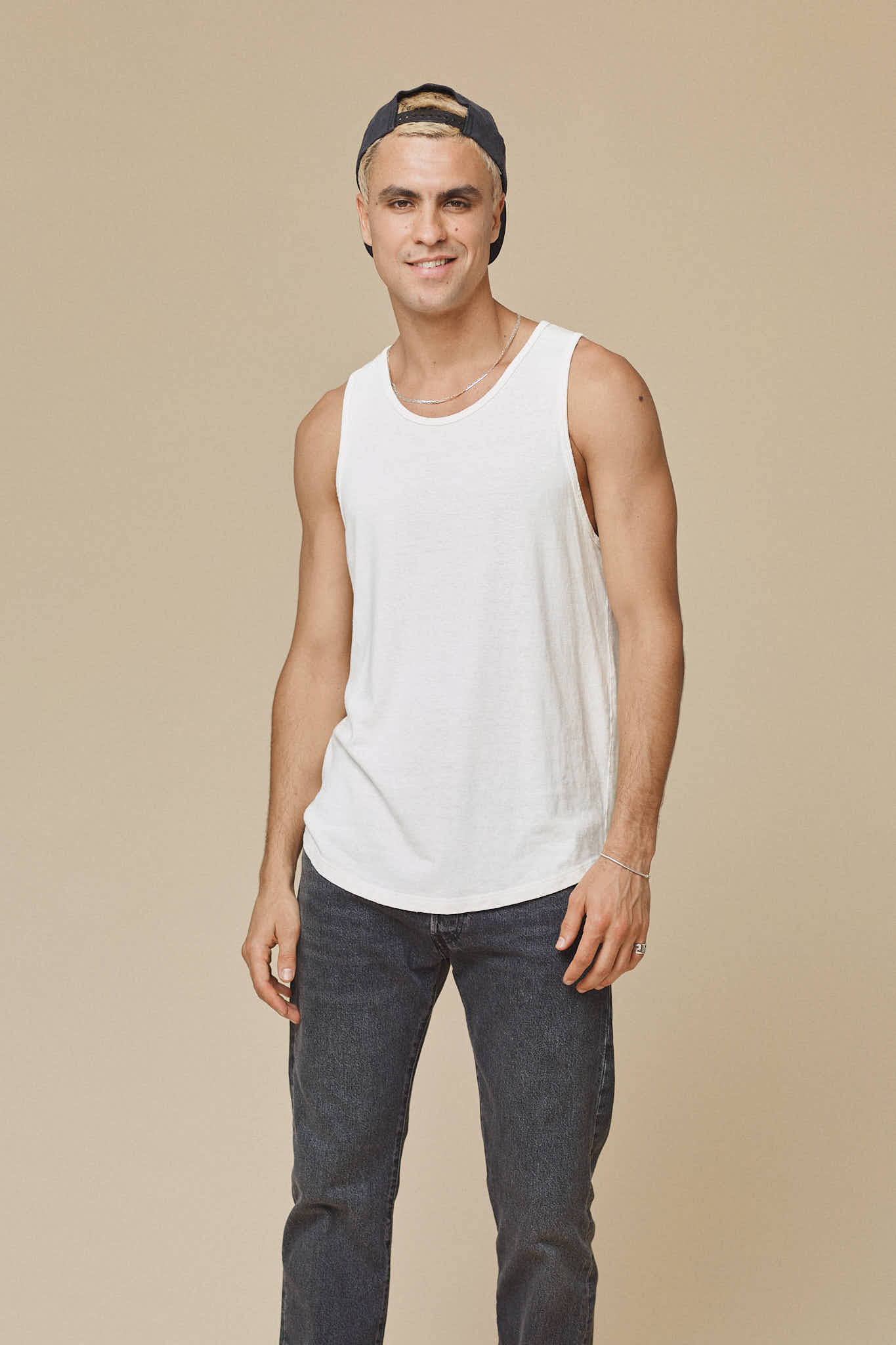 Royalty-Free photo: Man wearing white tank top and black fitted pants